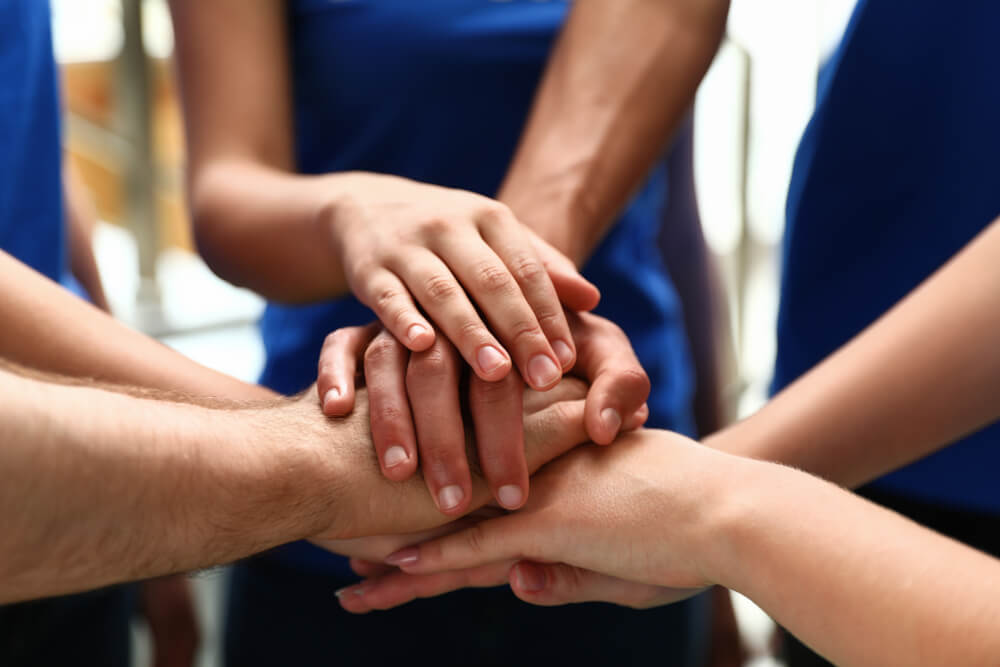 Group of Volunteers Joining Hands Together